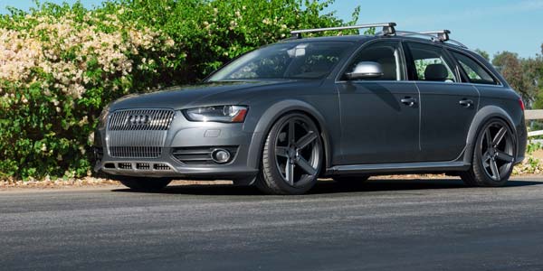 Grey Audi wagon with custom wheel and a roof rack.