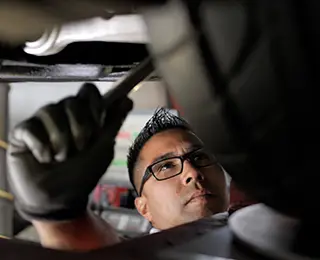 Technician working on a tie rod on a car