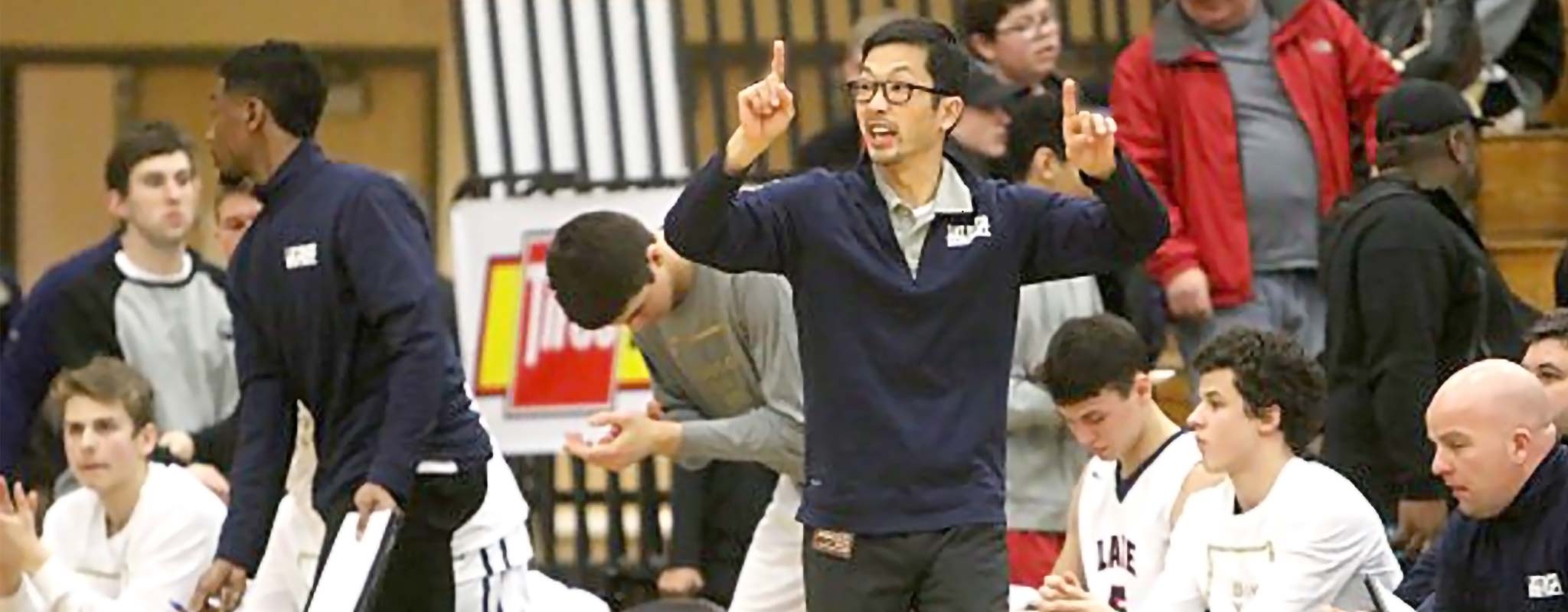Lake Oswego basketball coach, Marshall Cho, courtside during a game.