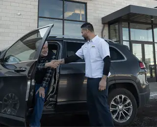 Les Schwab employee greets customer in the parking lot