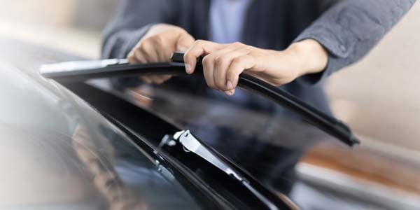 Person changing a windshield wiper blade